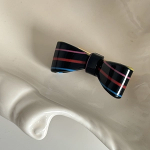 Candy striped acetate bow hair clip with colorful lines on polished black resin