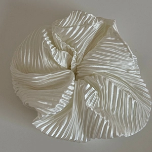 Vue détaillée du grand chouchou en satin blanc plissé avec une texture brillante ondulée