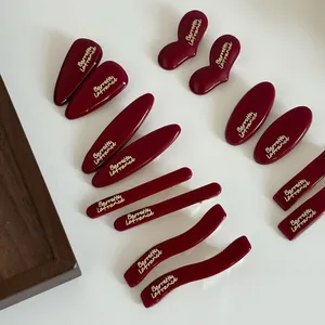 Deep burgundy geometric hair clips set with gold lettering and polished resin finish
