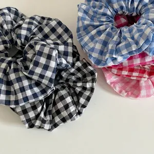 Various colorful plaid gingham scrunchies for hair in cotton fabric flat lay view