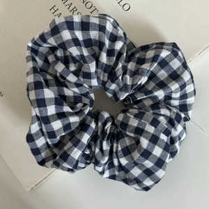 Detailed view of the black and white gingham fabric texture on a large scrunchie hair tie