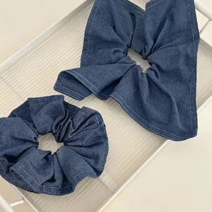 Chouchous en denim bleu avec surpiqûres blanches et motif de nœud papillon