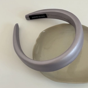 Minimalist lavender padded headband with handmade label on beige ceramic tray