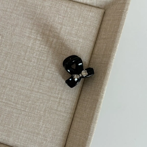 Barrette à cheveux nœud noir élégante avec strass cœur dans un plateau d'affichage
