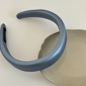 Detail of blue faux leather padded headband with handmade label and stitching