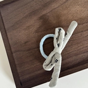Elastico per capelli con fiocco a fiori su un vassoio di legno di alta qualità