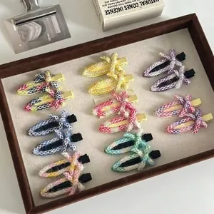 Colorful tweed woven bow hair clips in various pastel shades on a brown velvet tray