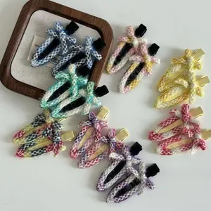 Close-up of assorted colorful tweed fabric bow hairpins with metal duckbill clips