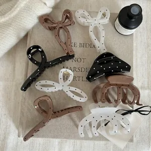 Set de pinces à cheveux à pois avec nœud papillon sur un fond en tissu beige