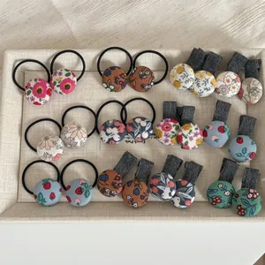 Ensemble de barrettes et chouchous en tissu floral avec de doux motifs champêtres sur plateau