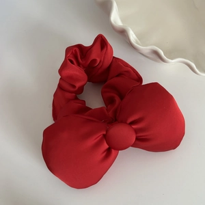 Elegant large red satin bow scrunchie for women with smooth glossy texture on white background