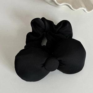 Detail of a large black bow scrunchie made of premium matte fabric for hair styling