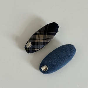 Detail of blue plaid and matte fabric hair clips set with silver metallic accents
