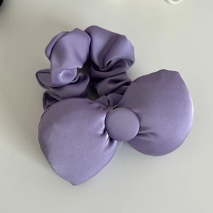Detailed close-up of a premium purple satin oversized bow scrunchie with silky finish