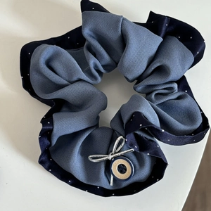 Detailed view of the blue polka dot and grey twill scrunchie with a fashion button