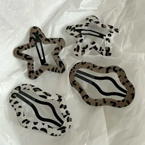 Close-up of leopard print hair clips in star and wavy shapes with velvet texture