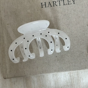 Vue détaillée du motif à pois sur la pince à cheveux crème avec une texture lisse