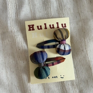 Detail of colorful plaid bow hair clips for girls on a decorative paper card