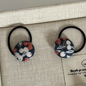Gros plan sur les barrettes en tissu avec motif floral de baies de style forestier