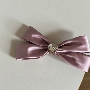 Dettaglio del fiocco in raso rosa con un centro in strass luccicante a forma di cuore