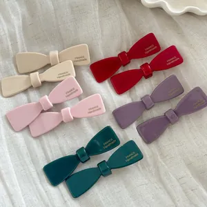 Detail of colorful bow hair clips with gold France Handmade lettering on fabric