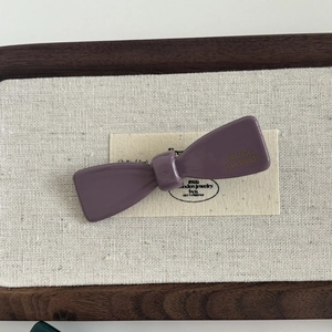 Detailed macro view of glossy acetate bow hair clip with France Handmade gold lettering