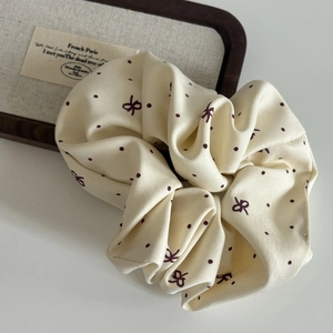 Polka dot bow scrunchie in cream fabric with elegant vintage design for hair styling