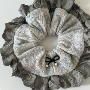 Detail of grey lace scrunchie with layered fabric and black bow with pearls
