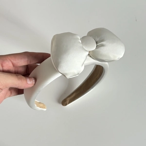 Chic white satin headband with a large 3D bow for facial care and makeup routines