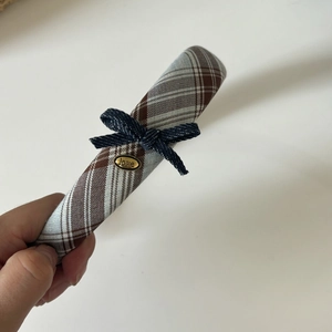 Detail of checkered headband with blue denim bow and golden love metal plaque