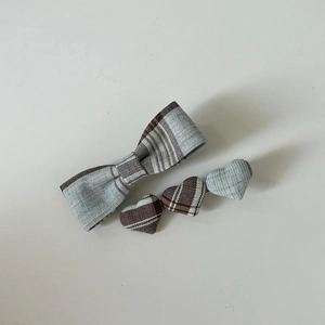 Detailed view of light blue plaid bow and triple heart hair clips in cotton fabric