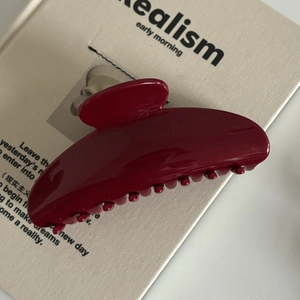 Pince à cheveux française en résine rouge foncé pour cheveux épais sur fond crème