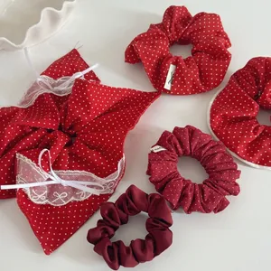 Détail de chouchous rouges à pois avec des nœuds en dentelle sur fond blanc