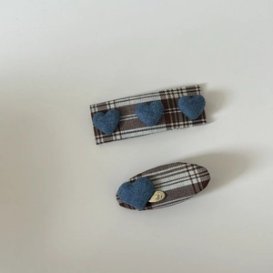 Detail of blue denim heart on brown plaid fabric hair clips with gold metal pendant