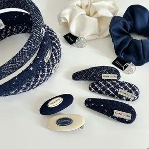 Detailed flat lay of blue tweed hairband and satin scrunchies with elegant textures