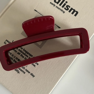 Gros plan sur la pince à cheveux rectangulaire rouge foncé avec finition brillante