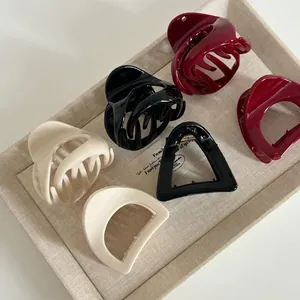 Set of 6 high-gloss resin pumpkin claw clips in cream, black, and dark red colors