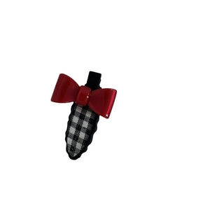 Barrette à cheveux avec nœud en résine rouge et tissu à carreaux noir et blanc sur fond blanc