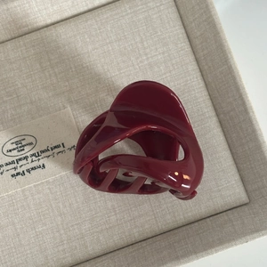 Glossy burgundy pumpkin-shaped hair claw clip in a minimalist cream jewelry box
