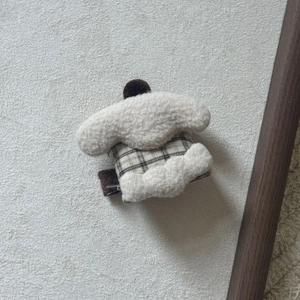 Close-up of handmade Cinnamoroll plush hair clip with brown checkered fabric detail
