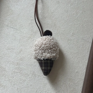 Detailed view of handmade cake ice cream necklace with plush texture and checkered fabric