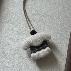 Close-up of mini brown plaid plush coat charm with faux sheepskin trim and brown cord