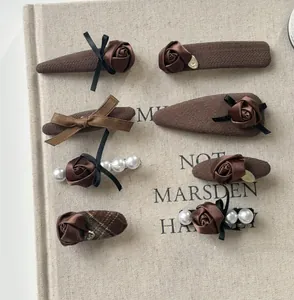 Detail of 8-piece vintage brown hair clips set with knit fabric and pearls