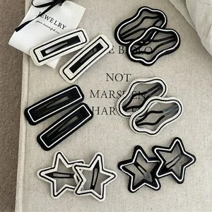 Set of minimalist black and white striped geometric hair clips with contrast stitching