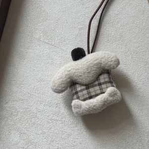 Detail of a plush cake-style pendant with Sherpa texture and brown checkered fabric