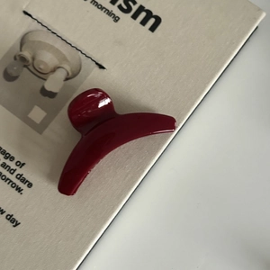 Détail d'une pince à cheveux rouge foncé brillante sur un magazine de mode