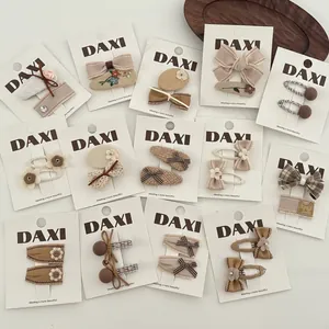 Vue détaillée du lot de barrettes à cheveux brunes brodées avec motifs à carreaux