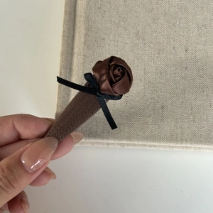Detail of vintage brown satin rose hair clip with black ribbon bow and velvet wrapped barrette