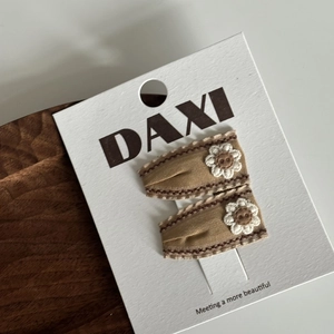 Gros plan de barrettes à fleurs crochetées à la main sur une carte de présentation de luxe