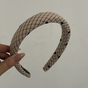 Detail of khaki plaid headband with small black heart patterns and thick padded design